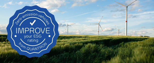 A beautiful grassy field with windmills in the distance under a blue sky